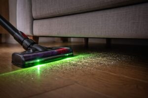 ソファ下の暗い場所でダイソンV12のレーザーがゴミを見やすくしているイメージ